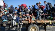 Central American migrants -mostly honduran- taking part in a caravan to the US, get on a truck heading to Irapuato in the state of Guanajuato on November 11, 2018 after spending the night in Queretaro in central Mexico.  AFP / Alfredo Estrella 