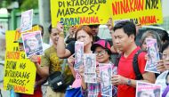 Anti-Marcos demonstrators display placards with portraits of Philippines' former first lady Imelda Marcos during a protest in front of the anti-graft court in Manila on November 13, 2018.  AFP / Ted Aljibe 
