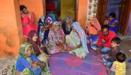 The Indian father (3rd R, in red) of a young boy who was killed by a macaques monkey sits with relatives at their family home in Agra on November 15, 2018.  AFP / Pawan Sharma