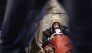 A homeless woman from north Wales sits huddled under a sleeping bag next to her dog Casper in a shopping arcade near the Victoria rail station in London, December 14, 2012. Reuters/Chris Helgren