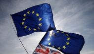FILE PHOTO: In this file photo taken on September 24, 2017 European and Union flags flutter in the breeze on the seafront in Brighton, during a march against Brexit. AFP / Daniel LEAL-OLIVAS
