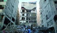 Palestinians stand near the rubble of a building that was completely destroyed by an Israeli air strike, in Gaza City on November 13.