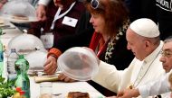 Pope Francis (R) looks at his meal as he has a lunch with destitute people, on November 18, 2018, at the Paul VI audience hall in Vatican, to mark the World Day of the Poor.  AFP / Vincenzo Pinto 
 