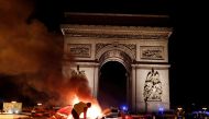 A protester is seen next to a burning barricade during a 