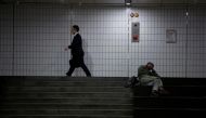 A man walks past a homeless man at an underground shopping district in Seoul, South Korea, July 12, 2016. Reuters/Kim Hong-Ji