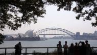 File photo of tourists standing in front of the Sydney Opera House and Harbour Bridge on a hazy day October 21, 2013. — Reuters pic