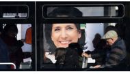 Commuters travel in a bus past an election poster of presidential candidate Salome Zurabishvili in Tbilisi on November 27, 2018, on the eve of the second round of presidential elections. / AFP / Vano Shlamov 