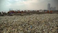 In this picture taken on March 17, 2018 workers clear up garbage piling up in Jakarta Bay area as part of the earliest local government combat against waste on its waters. / AFP / DASRIL ROSZANDI 