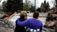 FILE PHOTO: Irma Corona (R) comforts neighbor Gerryann Wulbern in front of the remains of Wulbern's home after the two returned for the first time since the Camp Fire in Paradise, California, U.S. November 22, 2018. REUTERS/Elijah Nouvelage