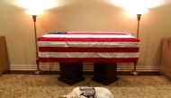 Sully, the service dog of George HW Bush in his final months, lays in front of Bush's casket at the George H. Lewis & Sons funeral home in Houston, Texas, December 3, 2018. Evan Sisley/George HW Bush office / via Reuters