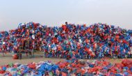 A Nepali volunteer ties up recycled plastic bags to make a sculpture shaped like the Dead Sea to set a new world record for the largest sculpture made out of recycled plastic bags, in Kathmandu on December 5, 2018.  AFP / PRAKASH MATHEMA
