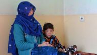 This picture taken on December 3, 2018 shows Murtaza Ahmadi, a supporter of Argentine footballer Lionel Messi, sitting next to his mother inside their home in Kabul. AFP / NOORULLAH SHIRZADA /