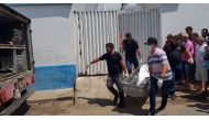 Forensic experts carry a corpse to be transported to the morgue after an attempted bank robbery in Milagres, Ceara state, Brazil on December 07, 2018. AFP / Agencia Miseria / Normando Soracles 
