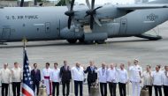 Philippine and US officials, including representatives from the Catholic church, pose for photos next to three Balangiga church bells shortly after they arrived from the US at a military airbase in Manila on December 11, 2018.  / AFP / Ted ALJIBE 