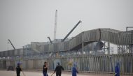 File photo: Workers walk in front of the Hebei Zongheng Iron and Steel plant that is under construction at the Tangshan Fengnan Economic Development Zone, Hebei province, China, August 22, 2018. REUTERS/Thomas Peter/File Photo