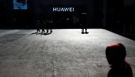 A man uses his phone as he sits in front of a Huawei shop in Beijing, China, December 11, 2018. Reuters/Thomas Peter
