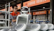 An employee assembles a robot at a factory in Handan in China's northern Hebei province on August 27, 2018. The company provides personalized robots used for customer services. AFP