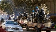 Malian riot police members arrive in vehicles as they deploy during a protest called by opposition parties in Bamako on December 8, 2018. / AFP / MICHELE CATTANI