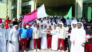 Qatar Olympic Committee (QOC) Vice President Sheikh Saoud bin Ali and QOC Secretary General Jassim Rashid Al Buenain along with other officials receive the national flag outside the QOC headquarters during the second edition of Al Adaam Flag Relay 2018, w