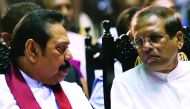 In this file photo taken on November 30, 2018, Sri Lanka’s President Maithripala Sirisena (R) listens to former president and currently-appointed Prime Minister Mahinda Rajapakse attend a ceremony granting employment to social service workers, in Colombo.