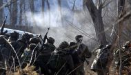 Indian army soldiers take cover near the site of a gun-battle between militants and government forces in Sirnoo Pulwama south of Srinagar on December 15, 2018.  AFP / STR
