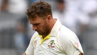 Australia's batsman Aaron Finch has his injured finger inspected after being struck by an Indian delivery on the third day of the second cricket Test match in Perth on December 16, 2018. AFP / WILLIAM WEST