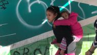 Children of Maria Meza, a 40-year-old migrant woman from Honduras, part of a caravan of thousands from Central America trying to reach the United States, on their way to the Otay Mesa port of entry in San Diego to be processed as an asylum seeker, in Tiju