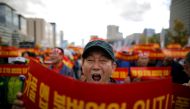 FILE PHOTO: A taxi driver takes part in a protest against a carpool service application that will be launched by Kakao Corp later this year, in central Seoul, South Korea, October 18, 2018. The banners read, 