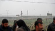 Turkish observation posts are seen on the Turkish side as Kurdish protesters gather to protest near the border wall separating Turkey from Syria in the western Syrian countryside of Ras al-Ain on December 20, 2018. AFP / Delil Souleiman