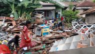 Children, who affected by the tsunami at Sunda Strait, collect snacks from a collapsed shop at Rajabasa in South Lampung, Indonesia, December 25, 2018. REUTERS/Stringer 