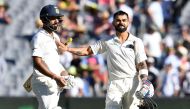 India's batsman Virat Kohli (R) greets his teammate Cheteshwar Pujara at the end of play on the day one of the third cricket Test match between Australia and India in Melbourne on December 26, 2018. AFP / WILLIAM WEST
