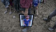 A person holds a picture of seven-year-old Jakelin Caal, who died in a Texas hospital two days after being taken into custody by US border patrol agents in a remote stretch of the New Mexico desert, during her funeral in the village of San Antonio Secorte