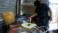 FILE PHOTO: A policeman inspects barrels containing stolen diesel fuel, stored in a tire repair shop, during an operation in the municipality of Apodaca, neighboring Monterrey July 4, 2011. Picture taken July 4, 2011. REUTERS/Josue Gonzalez/File Photo