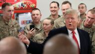 US President Donald Trump holds up a 
