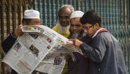 Bangladeshi people read a newspaper carrying headlines of the general election results in Dhaka on December 31, 2018. AFP / Indranil MUKHERJEE