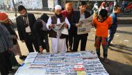 Bangladeshi people read newspapers carrying headlines of the general election results in Dhaka on December 31, 2018.  AFP / Indranil MUKHERJEE
