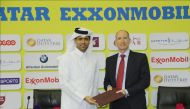 The President of Qatar Tennis, Squash and Badminton Federation (QTSBF) Nasser bin Ghanim Al Khelaifi (left) exchange documents with President and General Manager for ExxonMobil Qatar Alistair Routledge during the sponsorship signing ceremony in Doha yeste