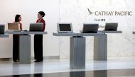 FILE PHOTO: Attendants chat at the First Class counter of Cathay Pacific Airways at Hong Kong Airport in Hong Kong, China April 4, 2018. REUTERS/Bobby Yip/File photo