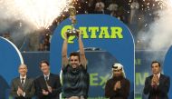 Spain's Roberto Bautista Agut (front) raises the trophy after winning against Czech Republic's Tomas Berdych the ATP Qatar Open tennis final match in Doha on January 5, 2019. / AFP / KARIM JAAFAR