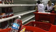 A group of people stand in line to pay at the checkout in a supermarket in Caracas, Venezuela on December 31, 2018. / YURI CORTEZ / AFP