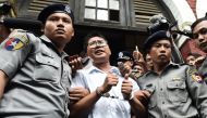 This file photo taken on September 03, 2018 shows Myanmar journalist Wa Lone (C) is escorted by police after being sentenced by a court to jail in Yangon. / AFP / Ye Aung THU 