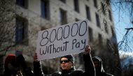 Filephoto: A demonstrator holds a sign, signifying hundreds of thousands of federal employees who won’t be receiving their paychecks as a result of the partial government shutdown, during a 
