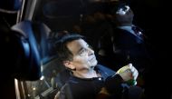 FILE PHOTO: Italian former leftist guerrilla Cesare Battisti sits in a taxi next to his lawyer Igor Tamasauskas as they leave the headquarters of the Federal Police in Sao Paulo March 13, 2015. REUTERS/Nacho Doce/File photo
