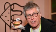 Impossible Foods CEO Pat Brown holds up an Impossible Burger 2.0, the new and improved version of the company's plant-based vegan burger that tastes like real beef, at a press event during CES 2019 in Las Vegas, Nevada on January 7, 2019.  AFP / Robyn Bec