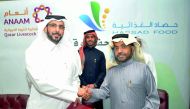Mubarak Rashid Al Sahuti (left), Executive Director of Business Relations, Hassad, shaking hands with Hamad Faleh Al Shahwani, Chairman of “Annam”, in the presence of Mohamed bin Badr Al Sadah (centre), Hassad Chief Executive Officer, during the signing c