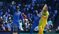 India's wicketkeeper Mahendra Singh Dhoni (L) shouts for a catch as Australia's batsman Shaun Marsh (C) plays a shot in the air during the first one-day International (ODI) match between Australia and India at the Sydney Cricket Ground in Sydney on Januar