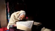 A Pakistani vendor of women garments reads the Quran while waiting for customers at his shop in Lahore on January 15, 2019. AFP / Arif Ali 





