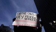 A protestor holds a sign during a rally outside a closed federal building in the Manhattan borough of New York City, New York, U.S., January 15, 2019. REUTERS/Carlo Allegri