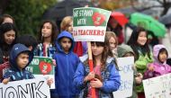 Students pose for a snapshot after walking the picket line with their teachers and parents on the third day of the teachers' strike, January 16, 2019, outside Dahlia Heights Elementary School in the Eagle Rock section of Los Angeles, California. AFP / Rob