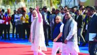 Indian Prime Minister Narendra Modi (L) waves as Gujarat state Chief Minister Vijaybhai Rupani (3L) and Deputy Chief Minister of Gujarat state Nitinbhai Patel (2L) look on at the Prime Minister's arrival, ahead of the inauguration of Vibrant Gujarat Summi